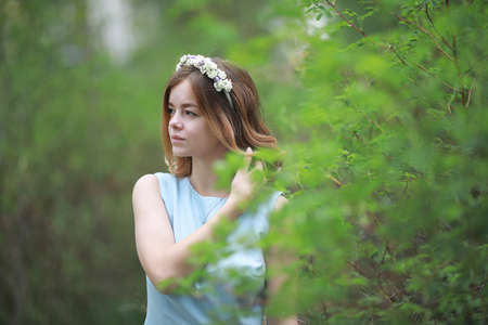 Girl in blue dress in green parkの写真素材