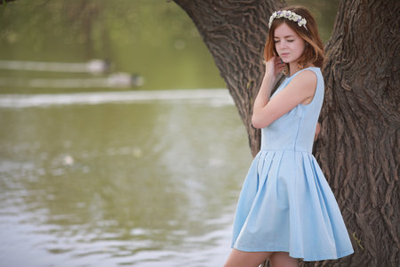Girl in blue dress in green parkの写真素材