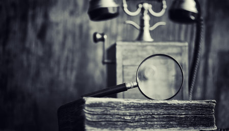 Old telephone and retro book on the desk. The phone of the past on an old wooden countertop....