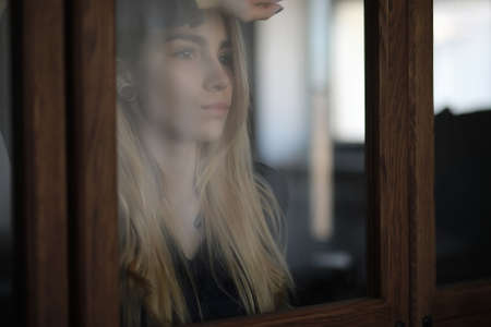 A young girl at home relaxing by the windowの写真素材