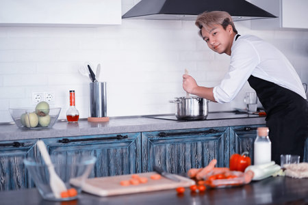 Asian cook in the kitchen prepares food in a cook suit
