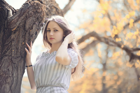 Young girl on a walk in the park in autumnの写真素材