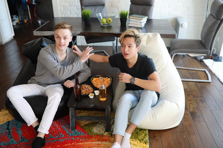 Football fans watching a match and drinking beerの写真素材