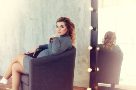 A beautiful pregnant young girl in a vintage homeの写真素材