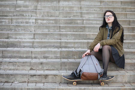 A young hipster girl is riding a skateboard. Girls girlfriends fの写真素材