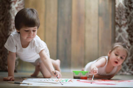Little children paint on a large sheet of paperの写真素材