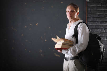 Student with long hair and a backpack with booksの写真素材
