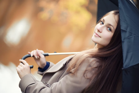 Young girl in a coat in autumn  parkの写真素材