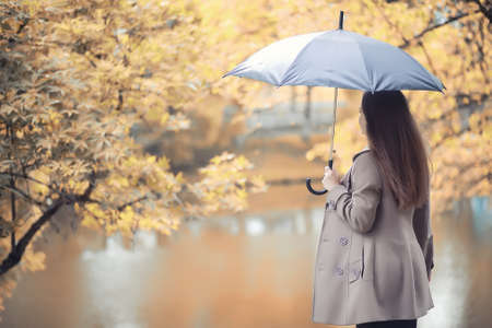 Young girl in a coat in autumn  parkの写真素材