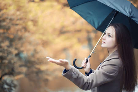 Young girl in a coat in autumn  parkの写真素材