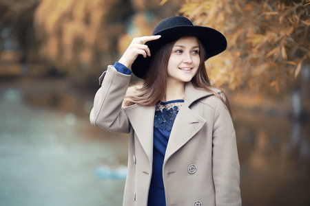 Young girl in a coat in autumn  park