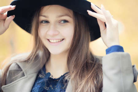 Young girl in a coat in autumn  parkの写真素材