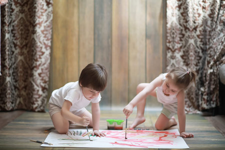 Little children paint on a large sheet of paperの写真素材