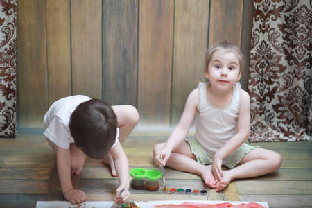 Little children paint on a large sheet of paperの写真素材