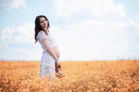 Pregnant woman in nature for a walk in the autumn