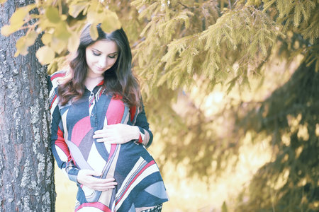 Pregnant girl in a dress in nature