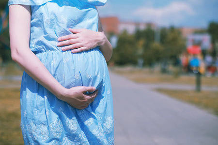 Pregnant girl in a dress in nature