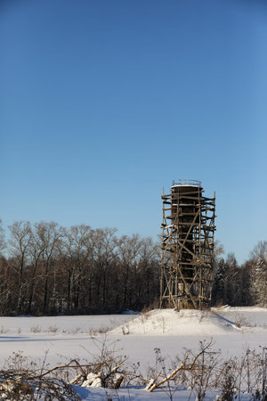 Scaffold around the water tower in the field in front of forestの写真素材