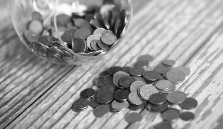 Coins in a jar on the floor. Accumulated coins on the floor. Pocket savings in piles.の写真素材
