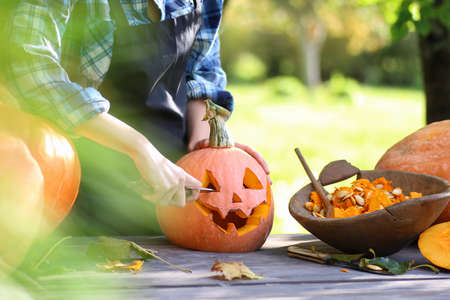 A hand is carving a pumpkin for halloween celebrationの写真素材