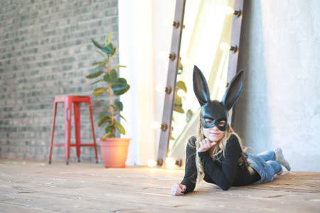 A girl in a black mask with long ears in the studioの写真素材