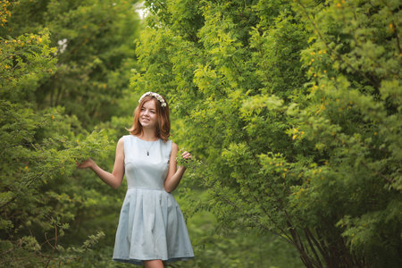 Girl in blue dress in green parkの写真素材