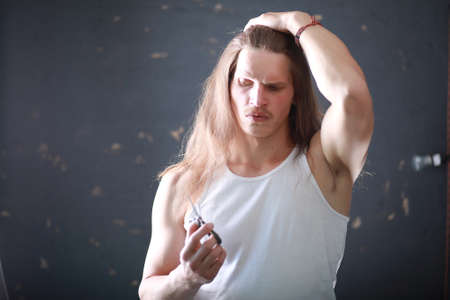 A young man with long hair cut a lockの写真素材