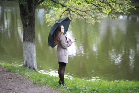 Young girl in a coat in a spring parkの写真素材