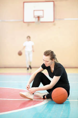 Girl in the gym playing a basketballの写真素材