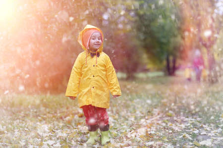 A child in a raincoat for a walk outside in autumnの写真素材