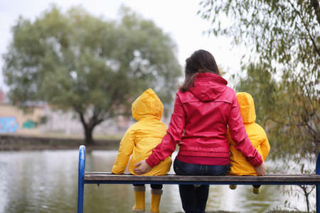 A child in a raincoat for a walk outside in autumn dayの写真素材