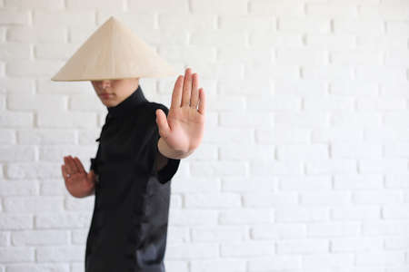 Asian young novice on a white brick wallの写真素材