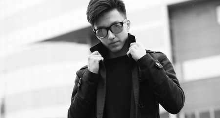 Black White photo of Asian young man outdoors posingの写真素材