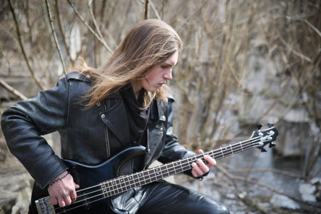Rock guitarist on the steps. A musician with a bass guitar in a