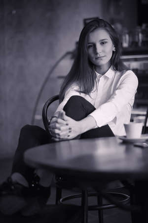 A girl in a cafe is drinking coffee. A woman is having breakfastの写真素材