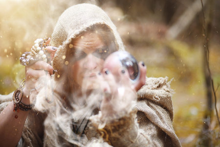A man in a cassock spends a ritual in a dark forestの写真素材