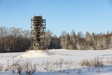 water tower near a river in front of a forestの写真素材