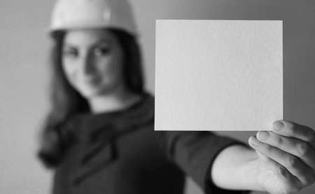 girl with a blank sheet of paper in his hand on construction sitの写真素材