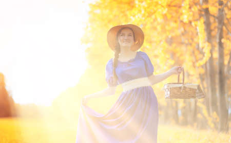 Young beautiful girl in dresses on nature. A girl in a hat walksの写真素材