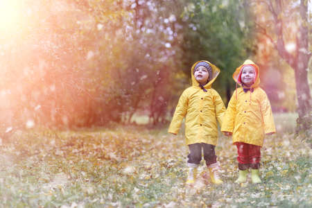 A child in a raincoat for a walk outside in autumnの写真素材