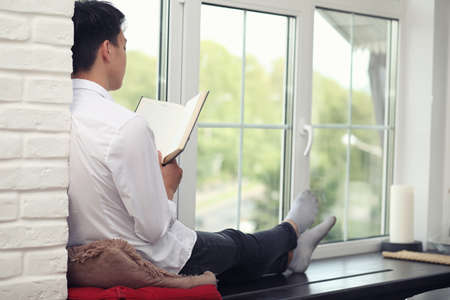 Asian young man student with books in handsの写真素材