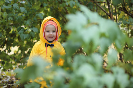 A child in a raincoat for a walk outside