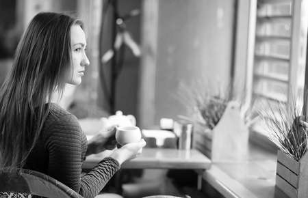 Girl in a cafe sitting and drinking teaの写真素材