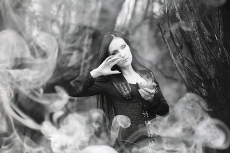 Woman in a witch suit in a dense forest
