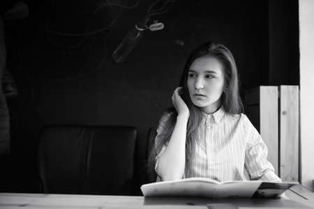 Girl with coffee. Young beautiful girl is sitting in a cafeの写真素材