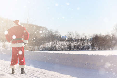 Santa Claus comes with gifts from the outdoor. Santa in a red suの写真素材