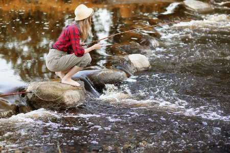 Girl in autumn with a fishing rodの写真素材