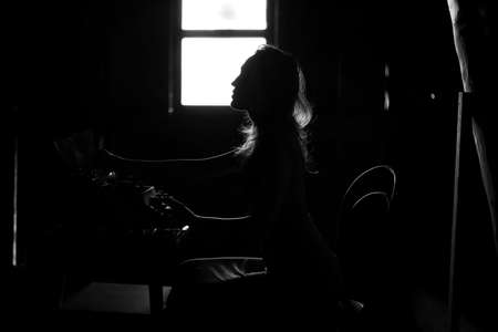 A girl prints on an old typewriterの写真素材