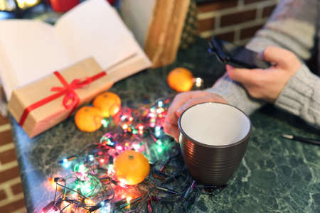 beard man writing christmas gifts on a table with old booksの写真素材