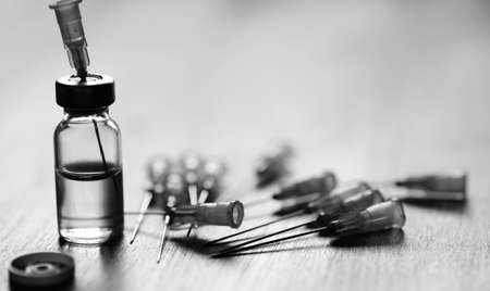 Ampoule and needles from a medical syringe on wooden backgroundの写真素材